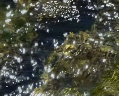 A still image of shimmering surface of moving river water.