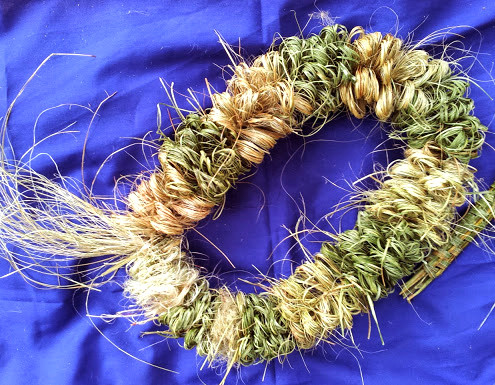 Densely woven circular item on a purple cloth.